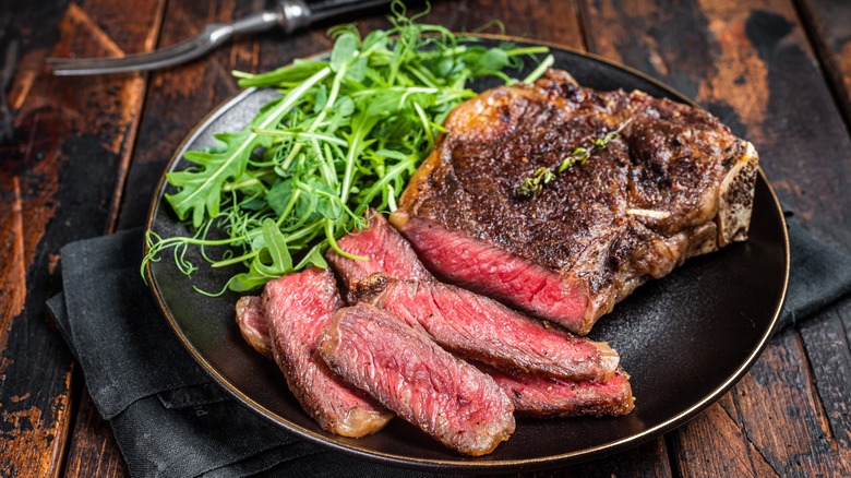 A plate of sliced steak and arugula salad