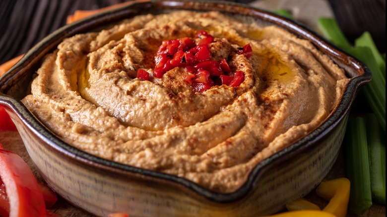 A bowl of hummus garnished with roasted red peppers