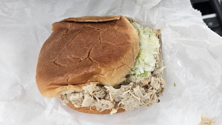 A pulled pork sandwich with coleslaw on wax paper from B's Barbecue