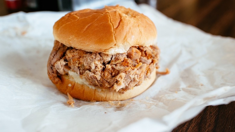 A pulled pork sandwich on wax paper from Skylight Inn BBQ