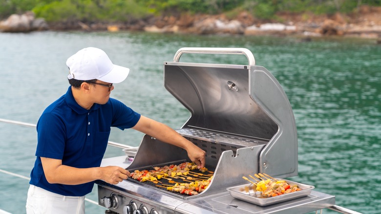 person grilling seafood near ocean