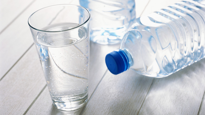 Glass of water with plastic water bottle