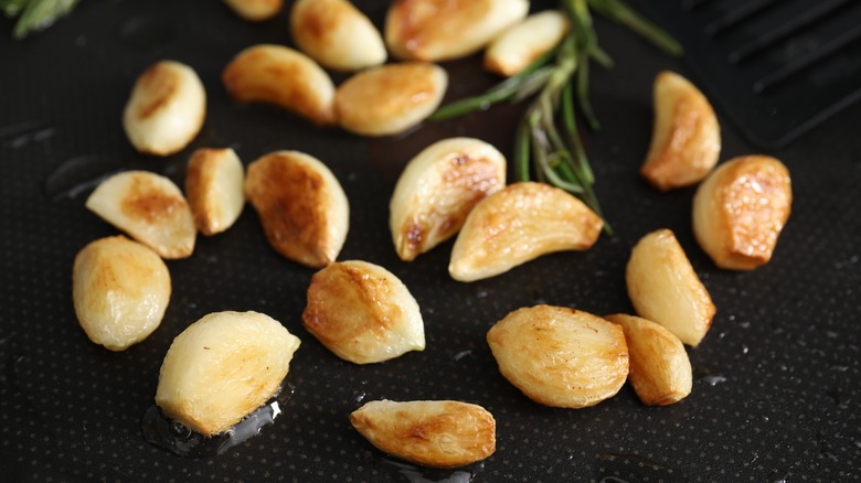 Garlic cloves in a pan with oil