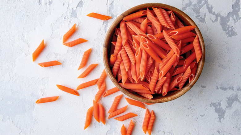 wooden bowl filled with red lentil penne pasta