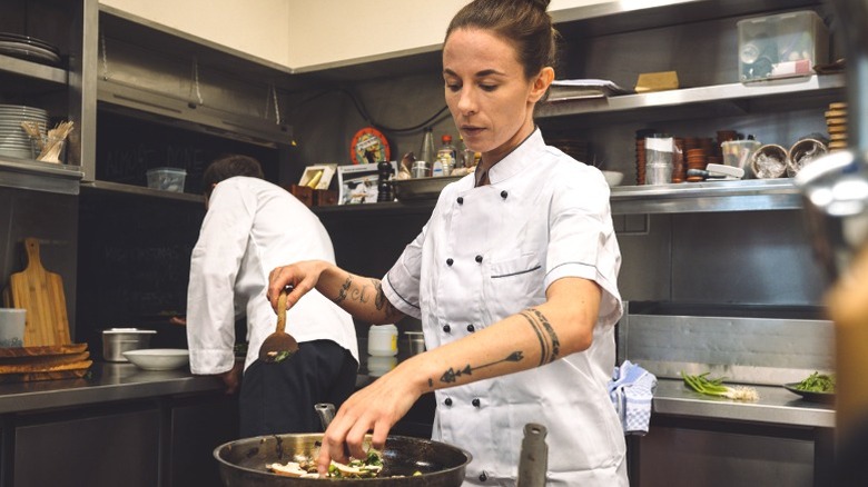 Female chef is cooking in a kitchen.