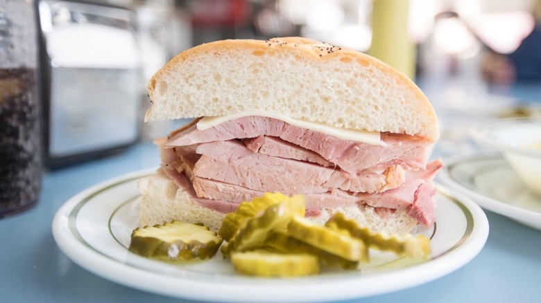 Half of a Detroit ham sandwich with side of pickle chips