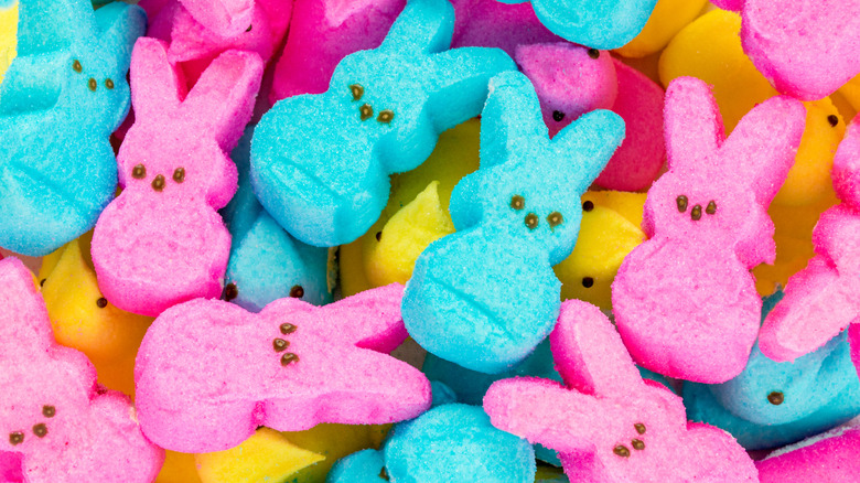 Pink and blue Marshmallow Peeps bunnies on top of yellow chicks