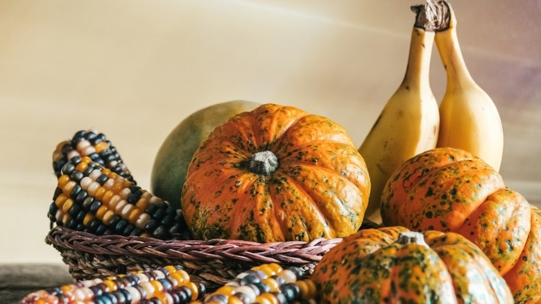 Pumpkins, corn, and bananas in basket