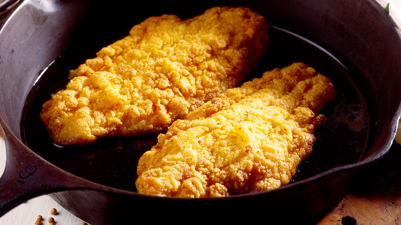 Catfish filets frying in cast iron