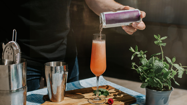 Pouring canned beverage into cocktail