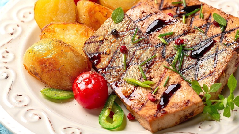 Close-up of grilled tofu steaks with cooked and sliced potatoes