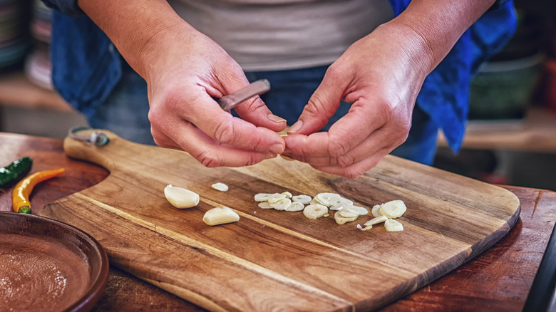 slicing garlic on a cutting board