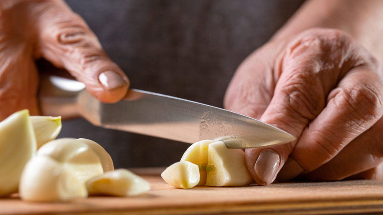 Person cutting garlic cloves