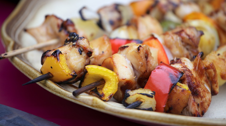 Plated chicken skewers with veggies.