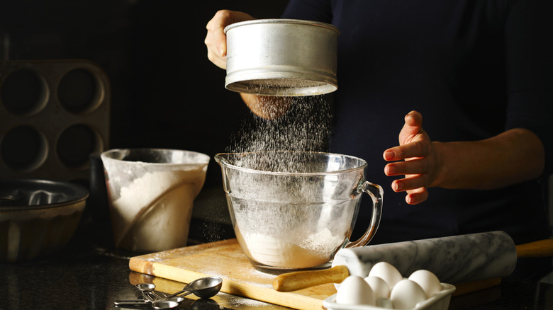 A person sifting flour