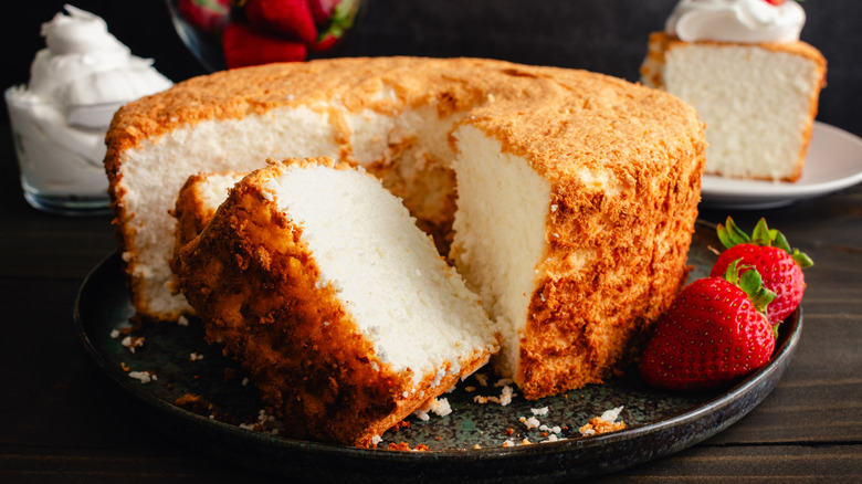 Sliced angel food cake on a plate with strawberries on the side