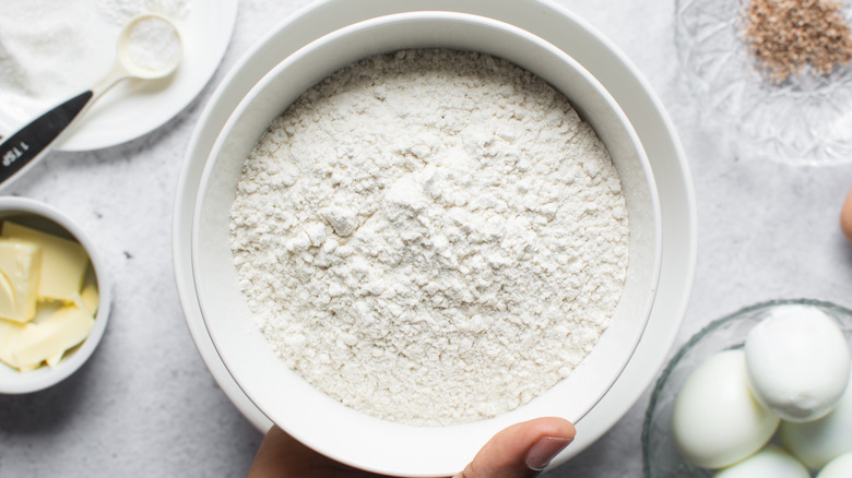 All-purpose flour in a bowl surrounded by other baking ingredients