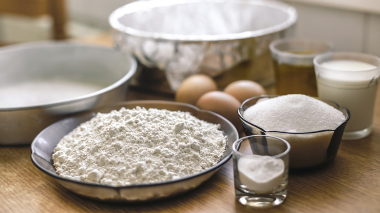 Flour in a dish pictured alongside baking ingredients in dishes