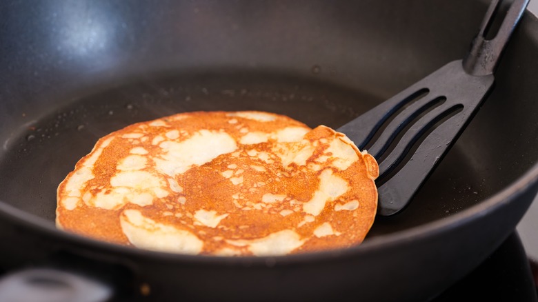Spatula lifting pancake off pan