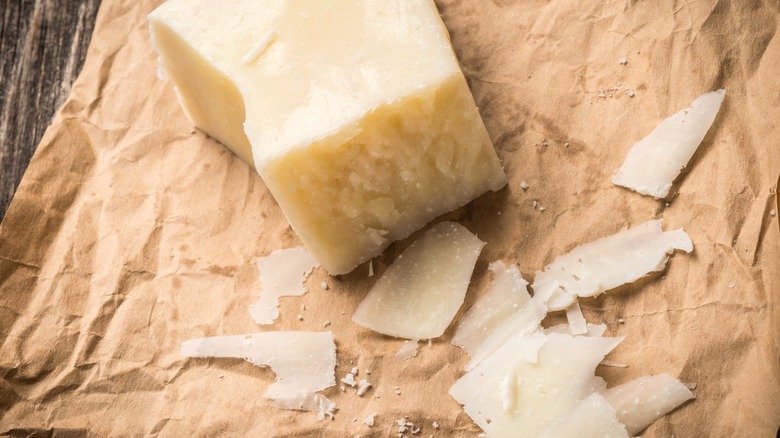 A block of Parmesan cheese and some very thin slices.