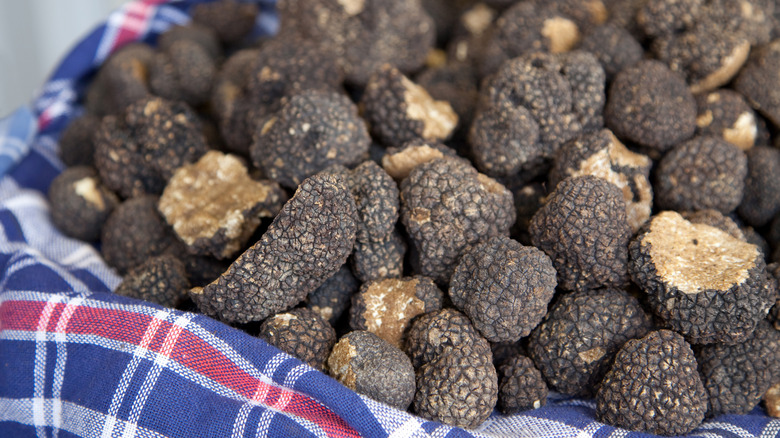 A basked stacked with black truffles.