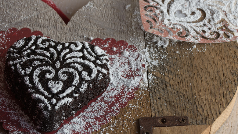 chocolate cake with lace-decorated powdered sugar