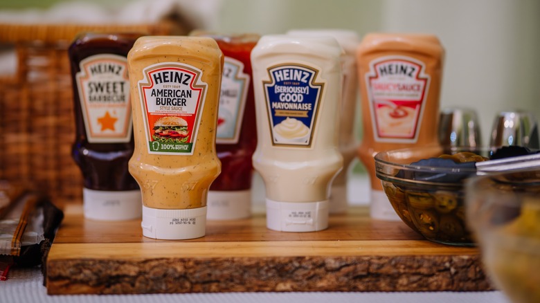 A variety of Heinz condiment bottles on wood board