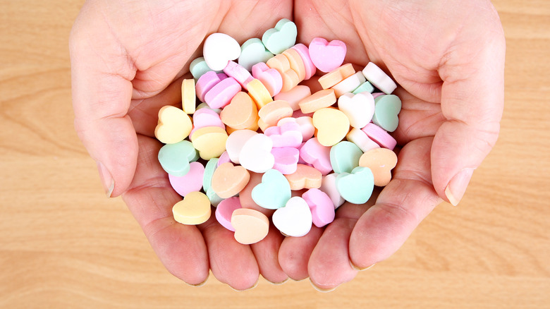 Hands holding candy hearts