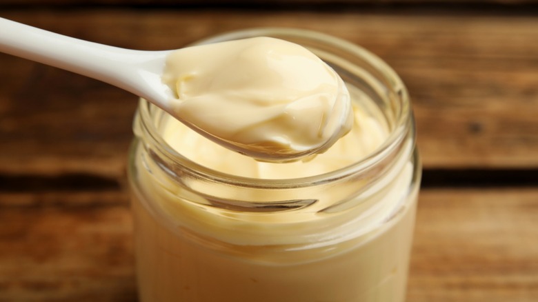 Spoon scooping mayonnaise from the jar