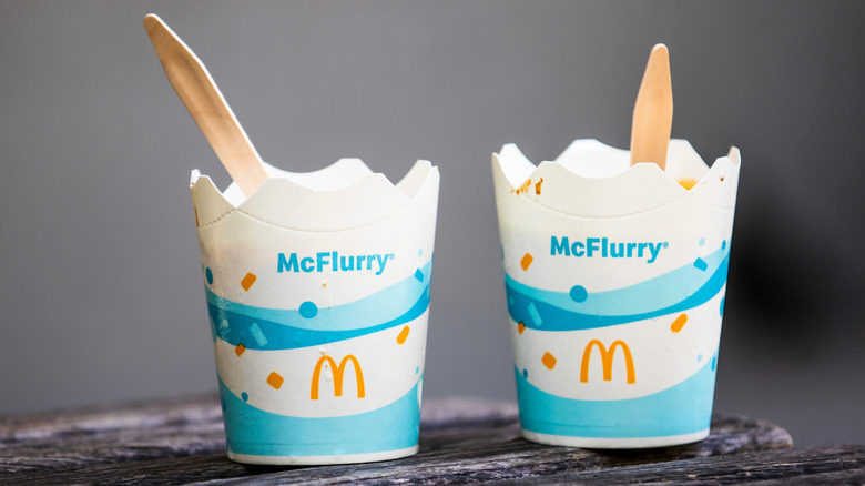 Two McDonald's McFlurry cups with wooden spoons on a table