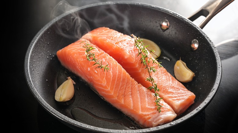Two salmon filets cooking in pan