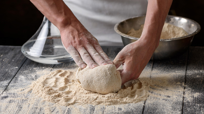 Person kneading pizza dough