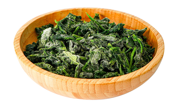 Frozen spinach sits in a wooden bowl.