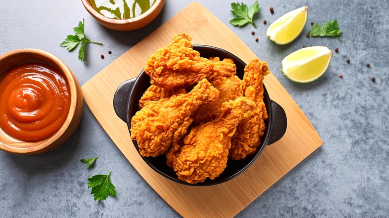 Fried chicken drumsticks in black bowl