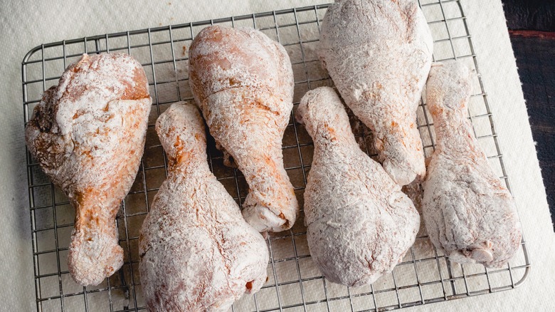 Raw floured chicken on rack