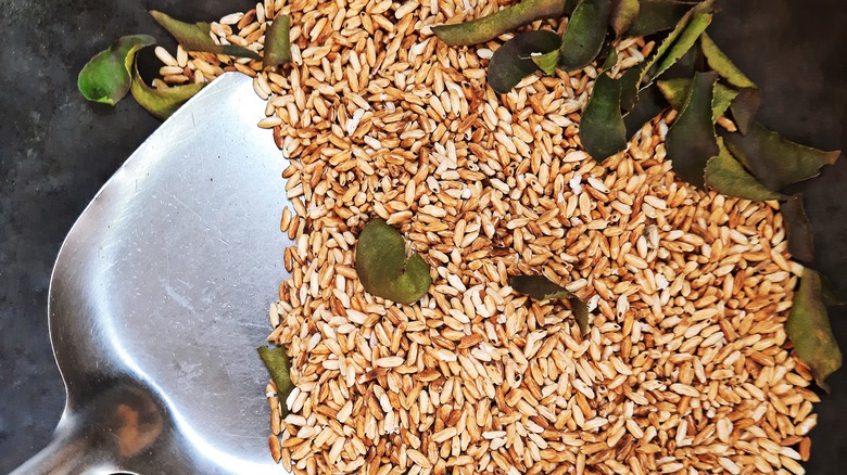 Hand adding olive oil to wok