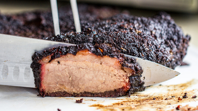 Slicing into brisket with bark