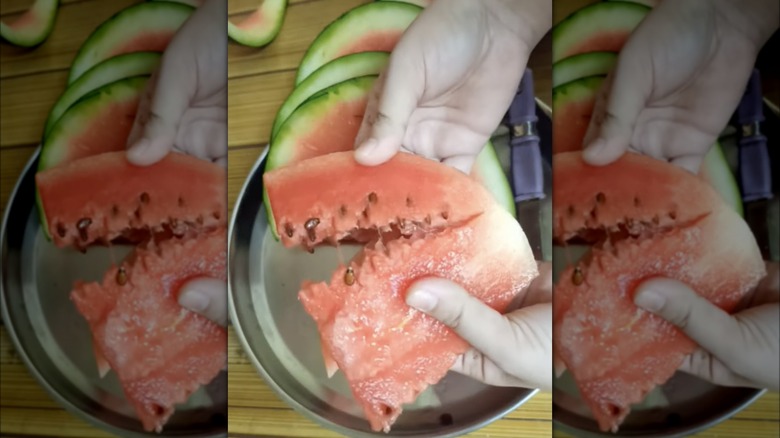 breaking slice of watermelon by hand