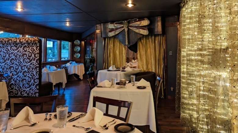 A fancy dining room with white tablecloth tables