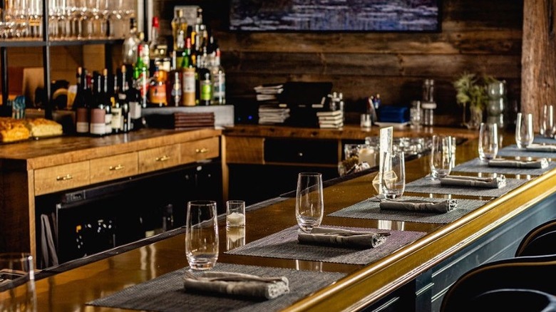 A wood-paneled bar with glasses and bottles
