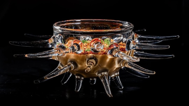 A professional shot of an octopus-like glass container filled with food
