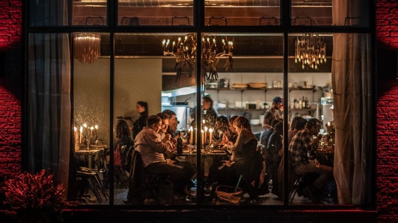 People dining in a candle-lit dining room