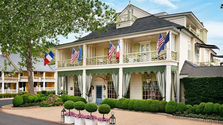 The exterior of a Victorian-style house with American flags