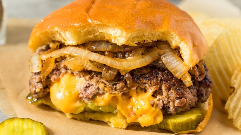 Juicy Lucy cheese-stuffed burger with onions and pickles