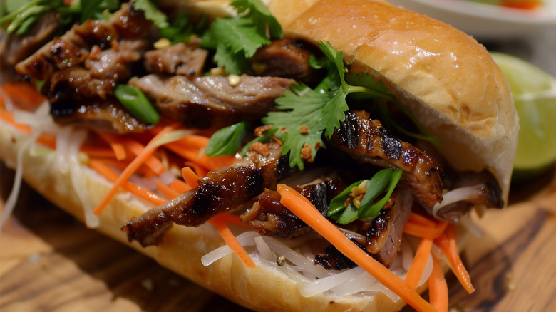 Closeup of a banh mi sandwich with grilled pork and pickled carrots and daikon