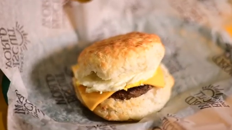 Sausage biscuit with cheese from Tudor's Biscuit World, sitting on opened wrapper