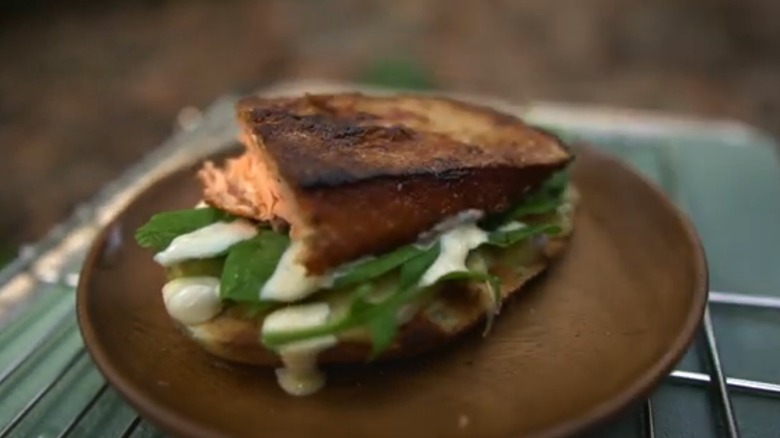 Open-faced trout sandwich with arugula, mayo, and cheese