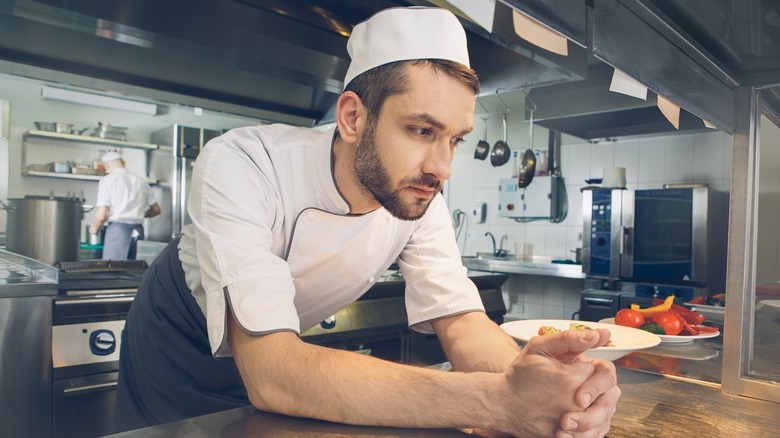 Chef leaning on restaurant pass