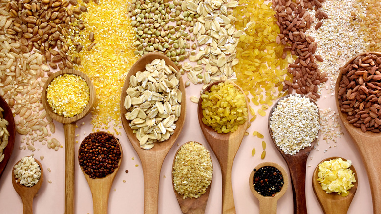 a variety of wooden spoons with different dried grains