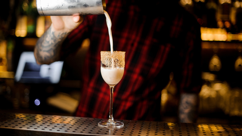 Pouring a brandy crusta into glass